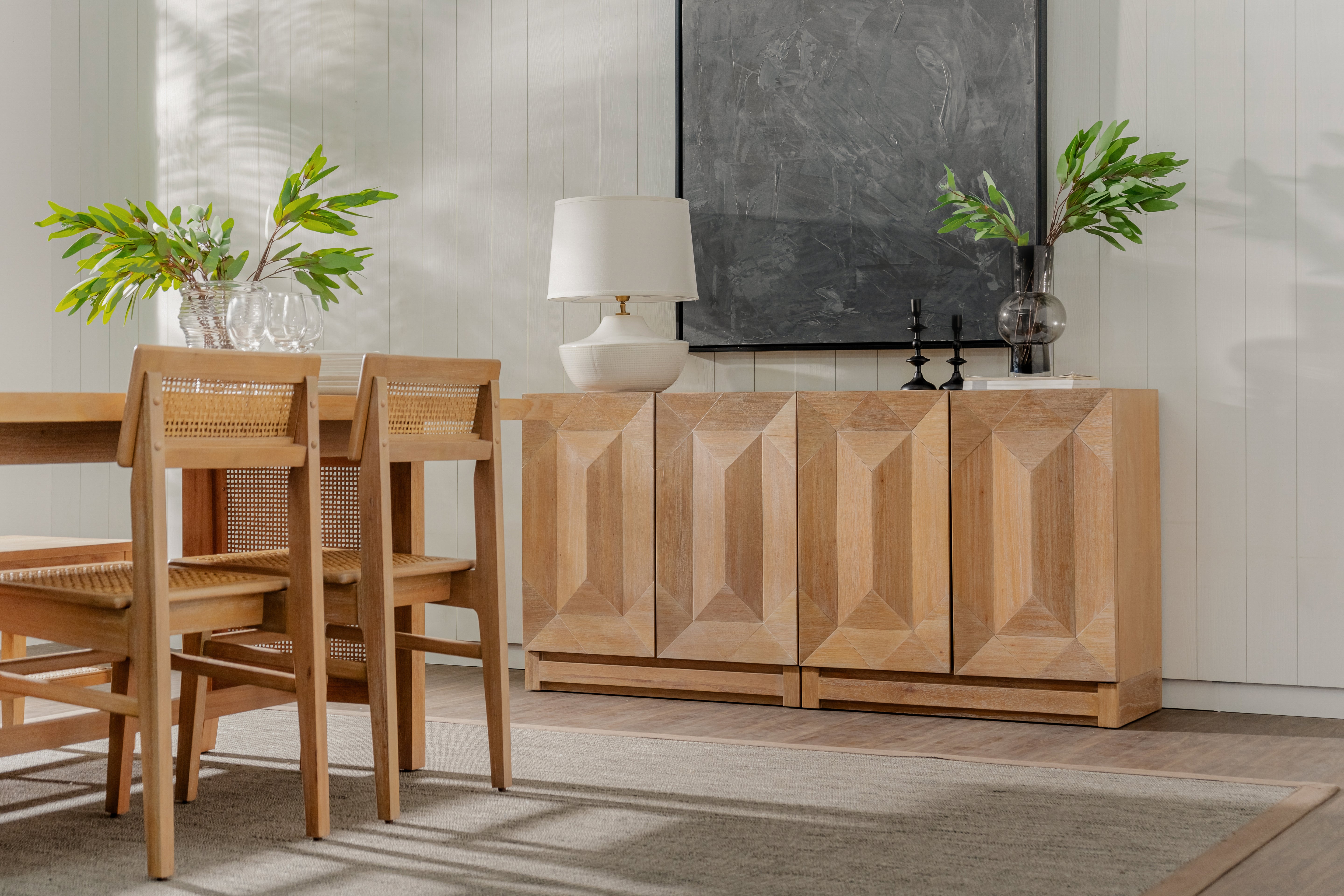 Natural Averi Modular Cabinet with chairs and a sideboard in a room with a television and plants.