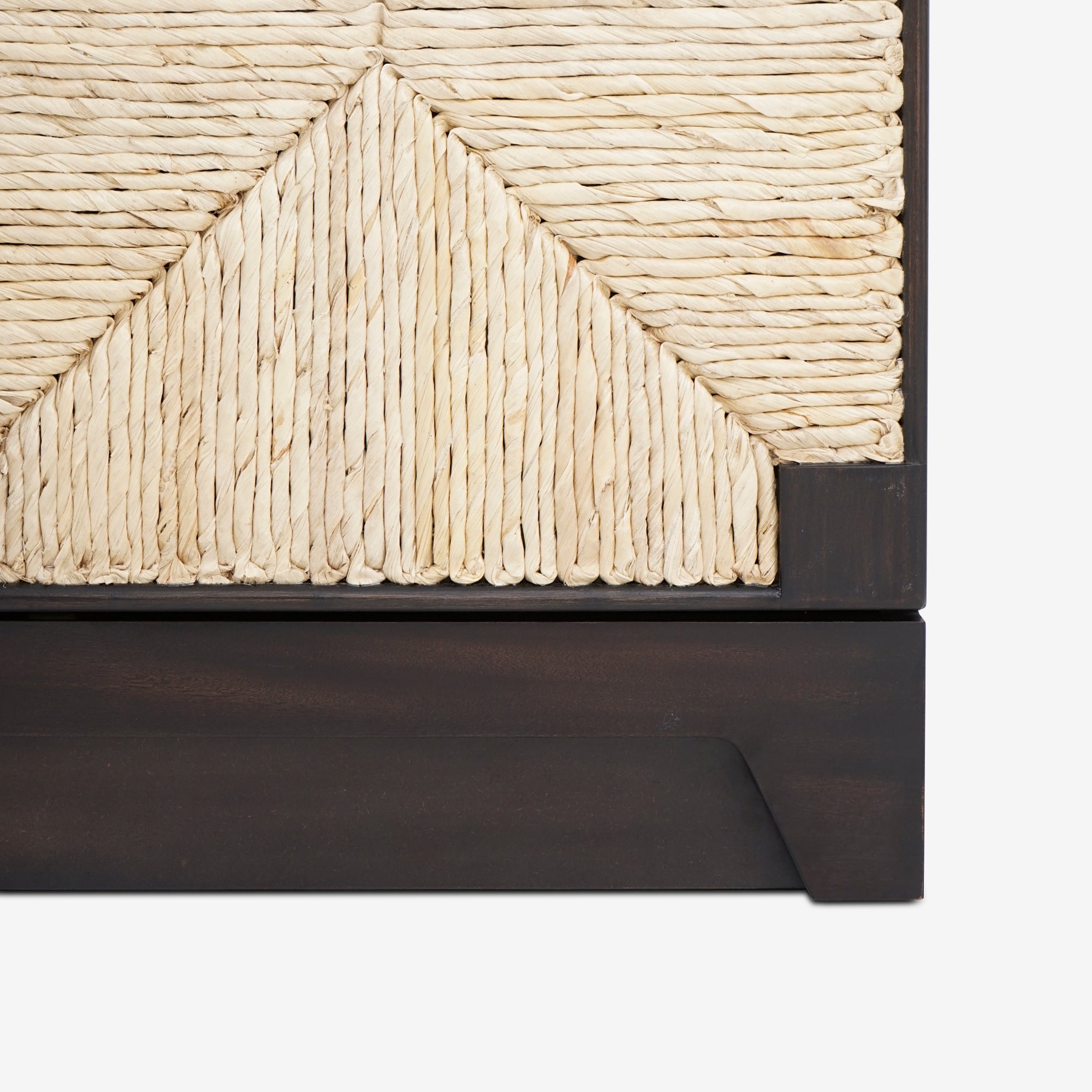 Close-up of a woven headboard with a dark wooden