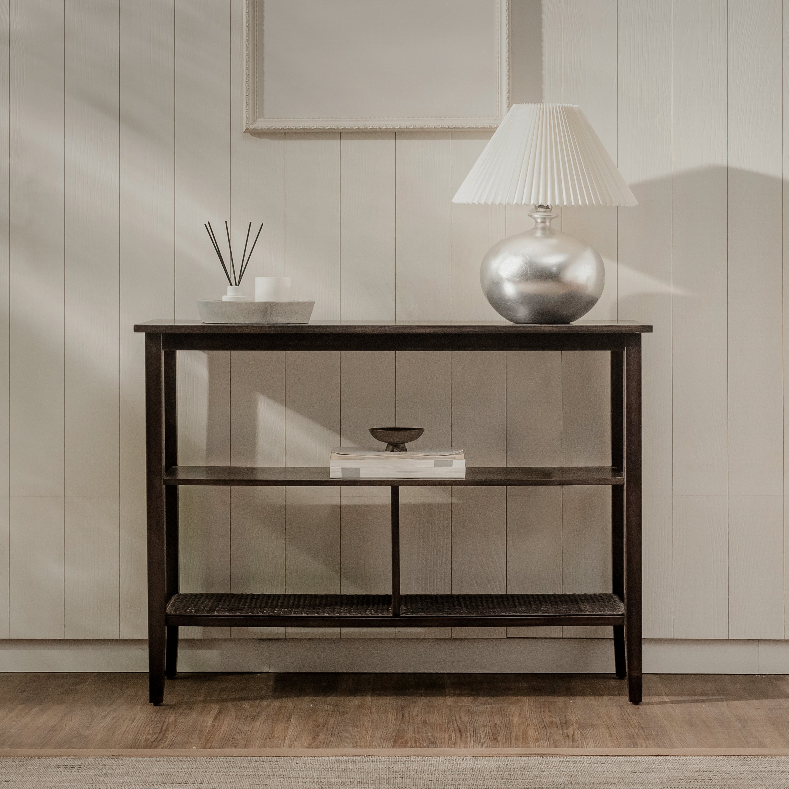 Wooden console table with decorative items against a neutral wall.