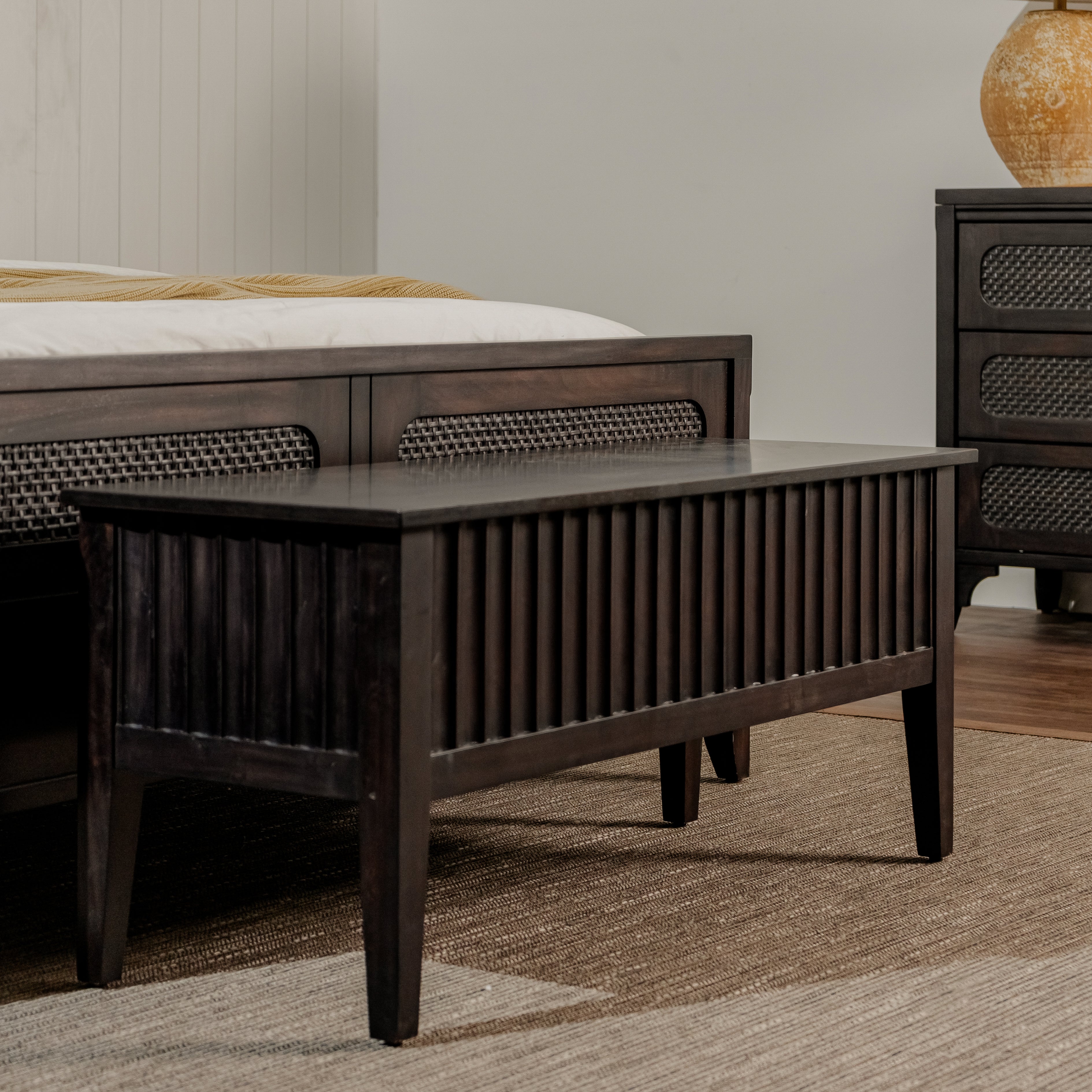 Wooden bed frame with textured surface in a bedroom setting