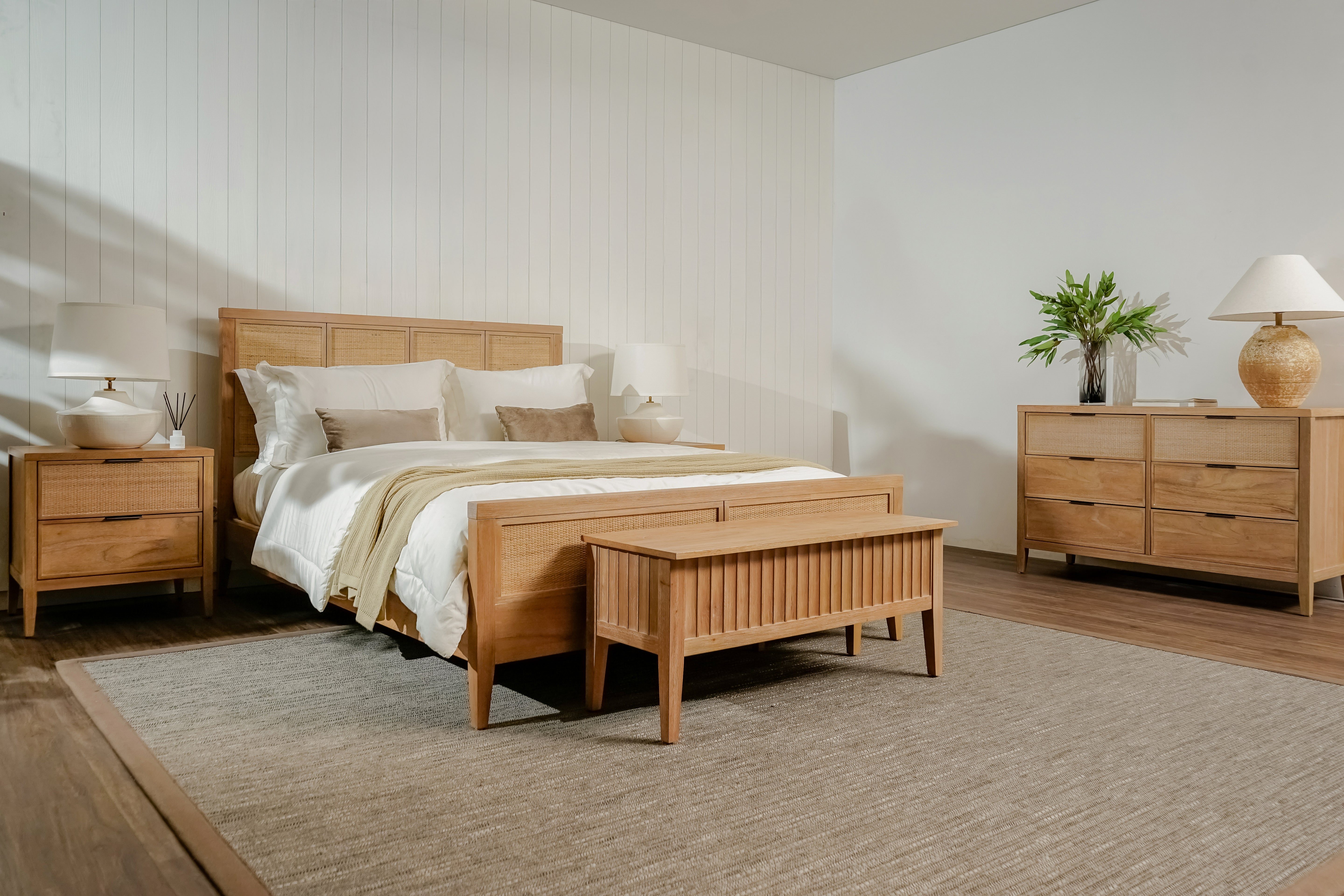 Wooden bedroom furniture set with bed, nightstands, and dresser in a room.