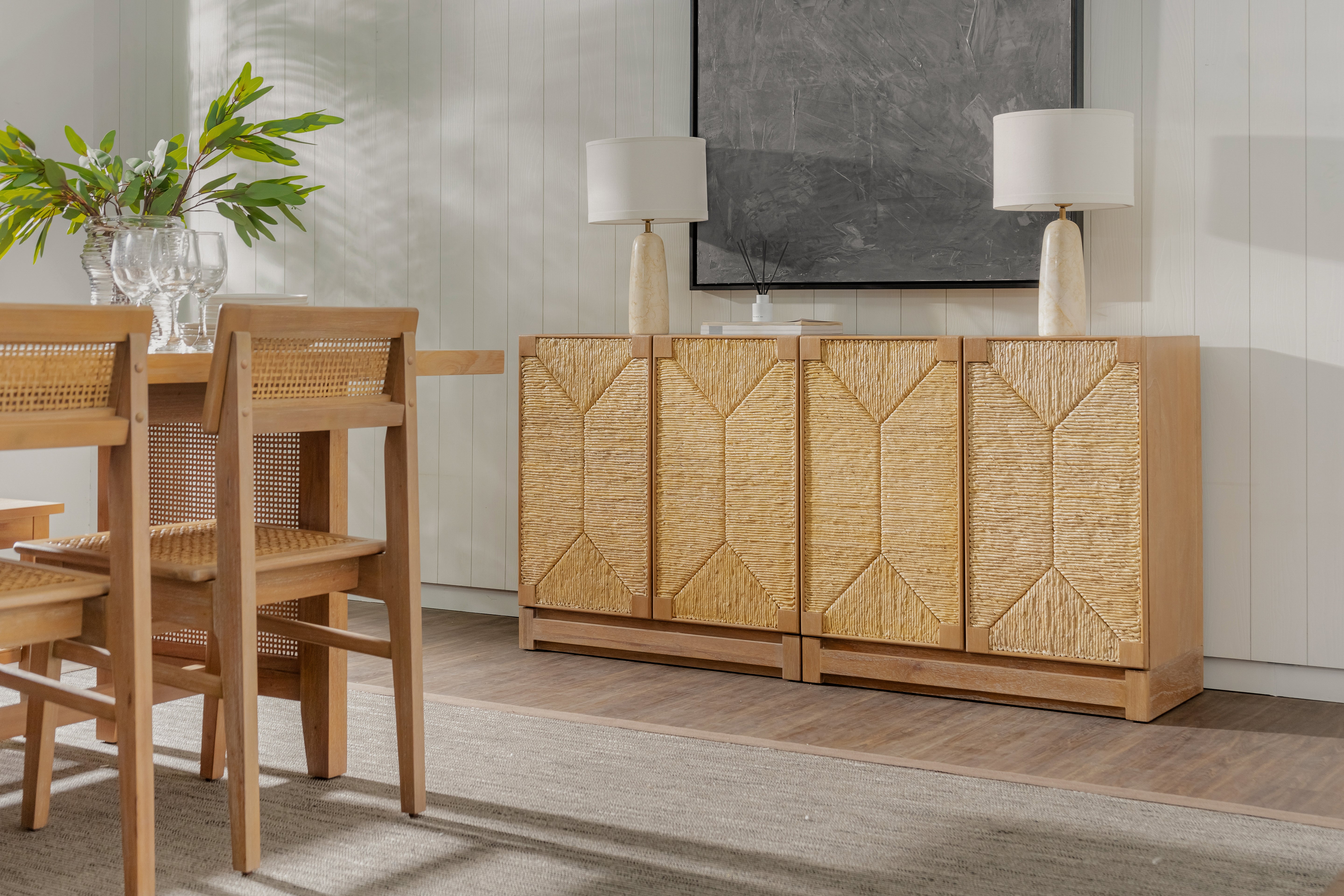 Wooden dining set with a sideboard in a room with a painting on the wall.