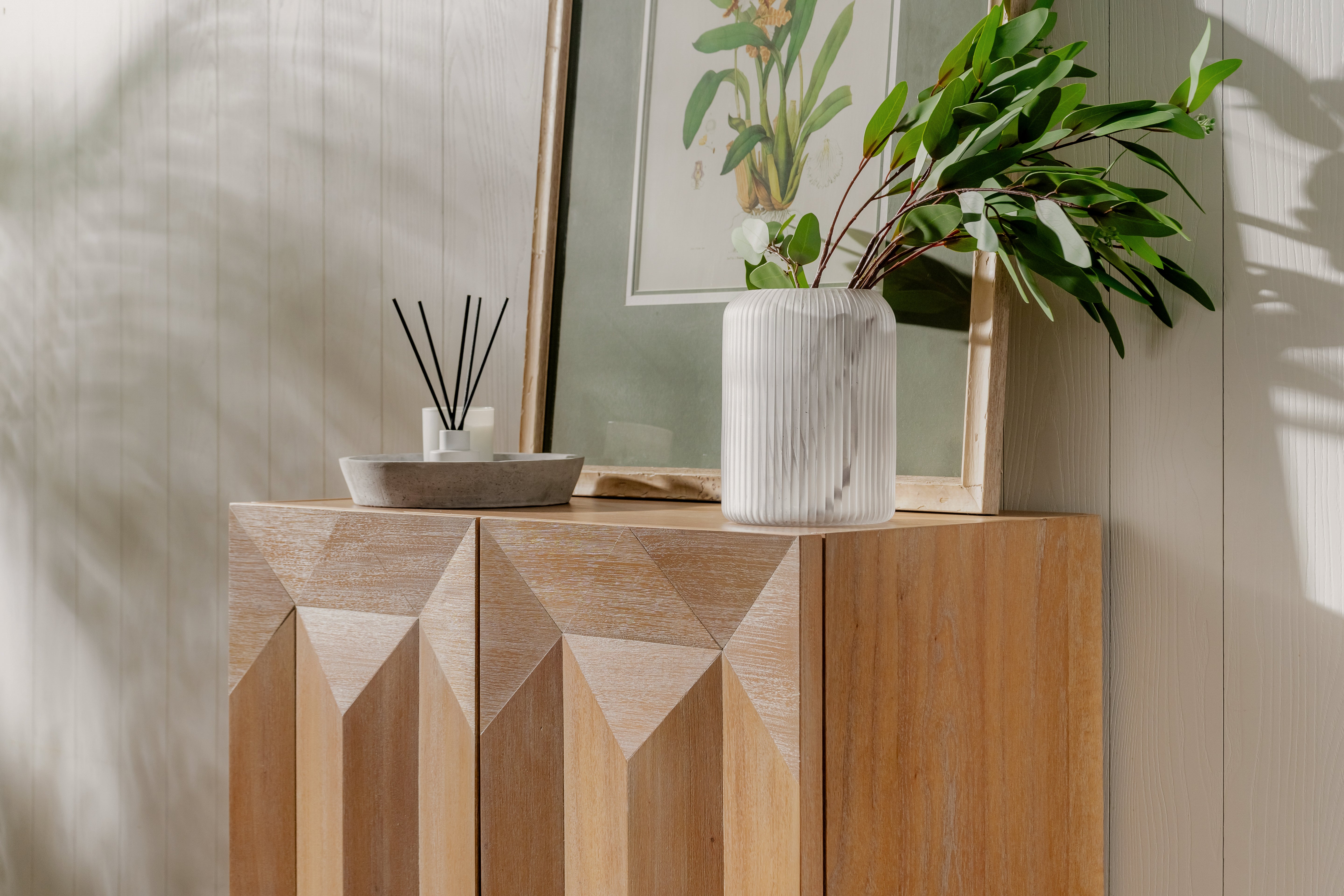 Natural Averi Modular Cabinet with decorative items and a plant in a room.