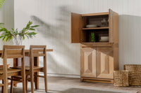 Wooden dining set with a Natural Averi Modular Cabinet in a room with light-colored walls and wooden floor.