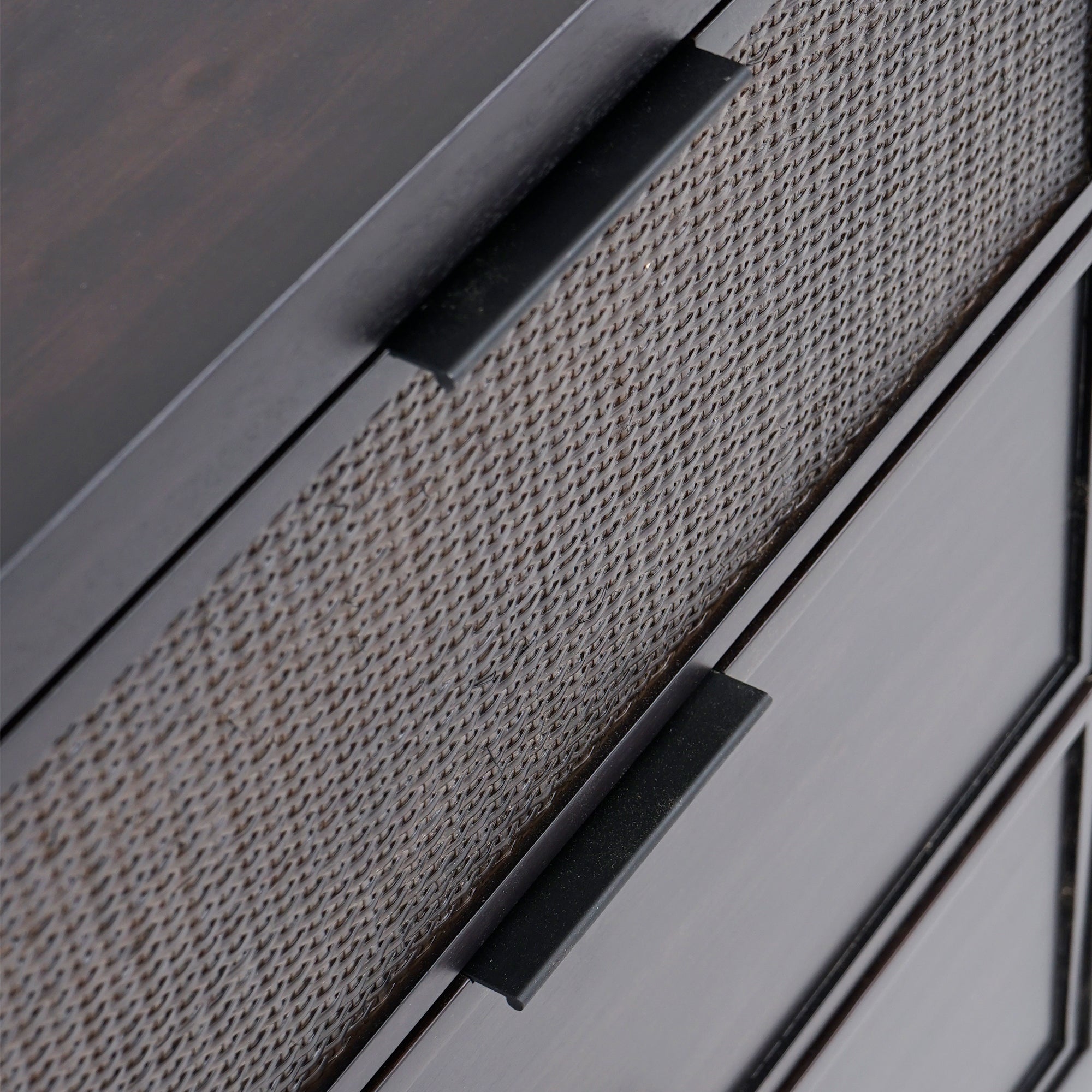 Close-up of a textured cabinet with black handles