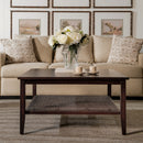 Living room with beige sofa, wooden coffee table, and floral arrangement.