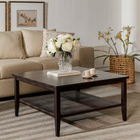 Living room with a dark wooden coffee table, beige sofa, and decorative elements.