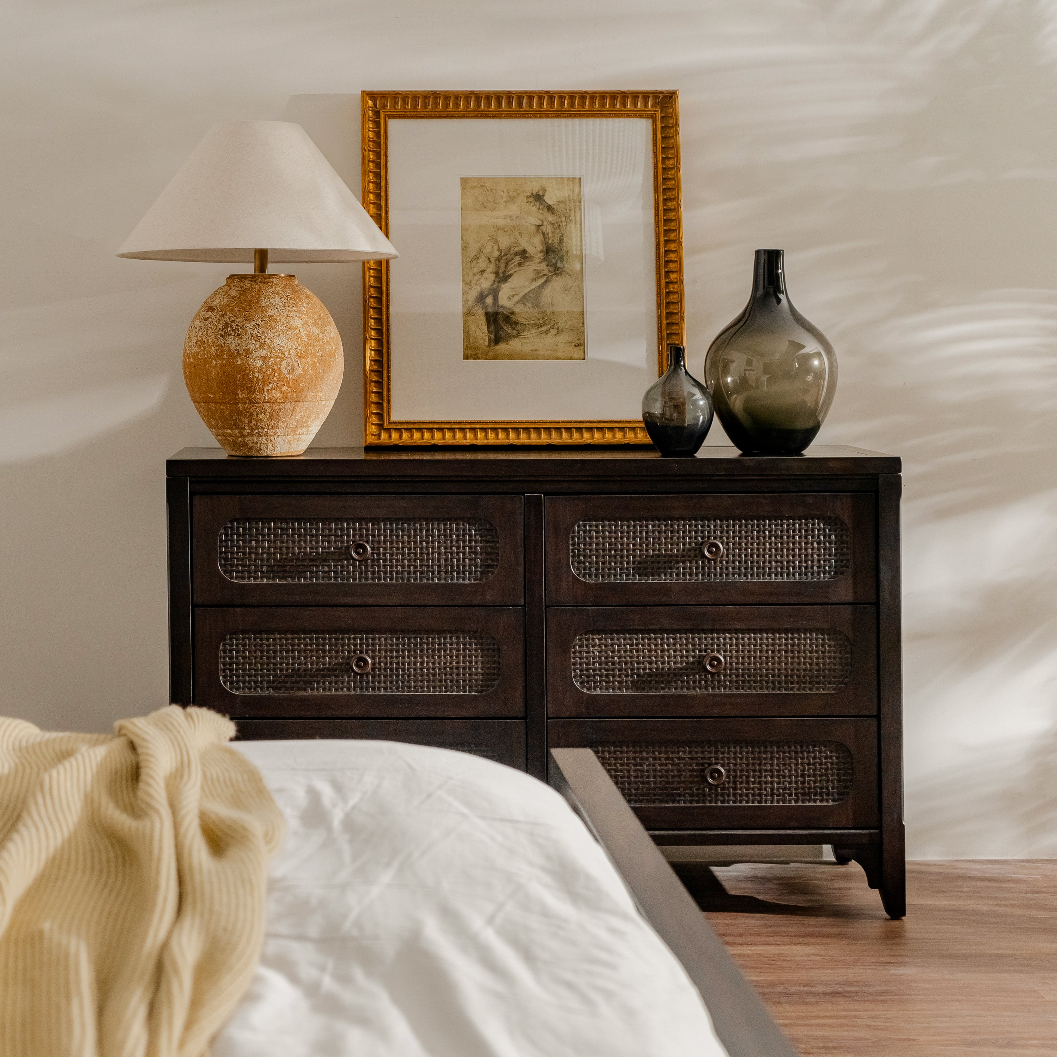 Wooden dresser with decorative items in a bedroom setting