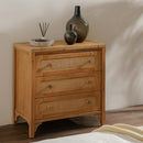Wooden chest of drawers with wicker-style handles and decorative vases on top.
